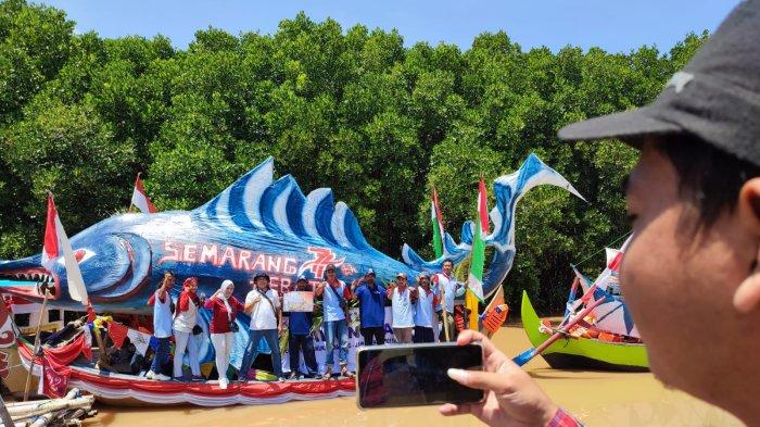 Para warga berfoto berlatar perahu hias di sungai Plumbon, Mangunharjo, Tugu, Kota Semarang, Sabtu (17/9/2022).