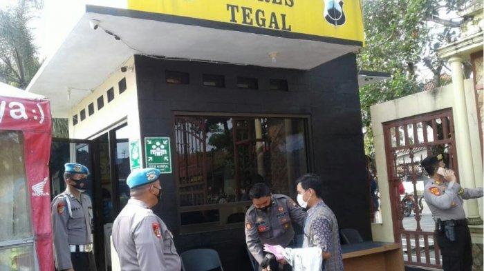 Suasana di halaman depan Polres Tegal jalan AIP KS Tubun, Pakembaran, Kecamatan Slawi, petugas berjaga dan memeriksa barang bawaan setiap orang yang akan memasuki area Polres, Kamis (1/4/2021). Hal ini merupakan tindak lanjut dari kasus penyerangan di Mabes Polri oleh seorang wanita pada Rabu (31/3/2021) kemarin.