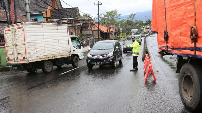 Polisi mengatur arus lalulintas karena adanya truk kontainer mengalami patah pada gandengan yang menyebabkan kemacetan panjang di Jalan Gatot Subroto Kabupaten Semarang, Jawa Tengah, Kamis (25/02/21).(Tribun Jateng/Hermawan Handaka)