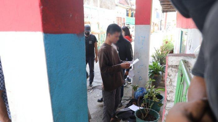 Salah seorang warga diperiksa oleh polisi saat memasuki Jl Tinumbu 1, Lrg 132, Makassar, Senin (29/3/2021).