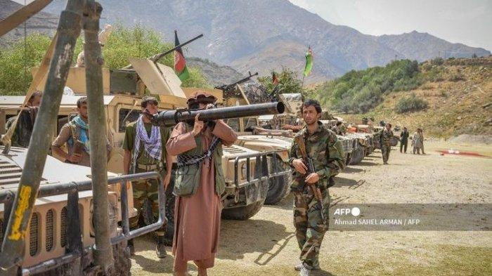 Seorang milisi berdiri bersama anggota pasukan pemerintah Afghanistan pada 19 Agustus 2021. Wakil Presiden Amrullah Saleh dan pemimpin milisi lokal Ahmad Massoud dilaporkan membentuk kembali kelompok perlawanan terhadap Taliban di Lembah Panjshir.