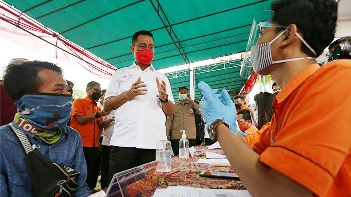 Menteri Sosial Juliari P Batubara berbincang dengan KPM Bansos Tunai dan petugas PT Pos Indonesia saat menyaksikan pencairan BST di Kantor Kecamatan Banyu Biru, Kabupaten Semarang (03/11). Kemensos meluncurkan BST untuk membantu meningkatkan daya beli masyarakat saat pandemi.
