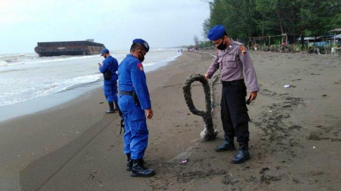 Anggota Polres Pemalang melakukan pengecekan di bibir pantai Kaliprau, Ulujami Pemalang, lokasi terdamparnya kapal tongkang, Minggu (1/2/2021).