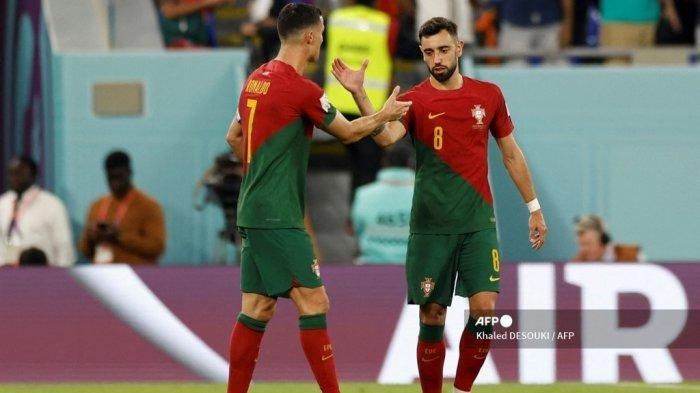 Penyerang Portugal #07 Cristiano Ronaldo (Kiri) diberi selamat oleh gelandang Portugal #08 Bruno Fernandes (Kanan) setelah mencetak gol pertama timnya dari tendangan penalti selama pertandingan sepak bola Grup H Piala Dunia Qatar 2022 antara Portugal dan Ghana di Stadion 974 di Doha pada 24 November 2022.
