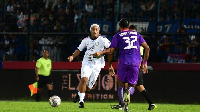 GIRING: Pesepakbola Ronaldinho menggiring bola dalam laga Trofeo Meet The Star di Stadion Kanjuruhan, Kabupaten Malang, Minggu (26/6/2022). Trofeo ini diikuti oleh Arema FC, Rans Nusantara FC dan Persik Kediri