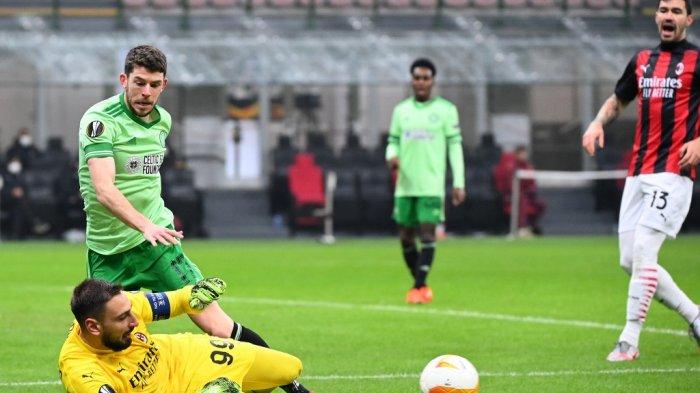 Penjaga gawang AC Milan Italia Gianluigi Donnarumma (Bawah) membersihkan bola di bawah tekanan dari pemain depan Celtic Skotlandia Ryan Christie (Kiri) selama pertandingan sepak bola Grup H Liga Eropa UEFA AC Milan vs Celtic pada 3 Desember 2020 di stadion San Siro di Milan.