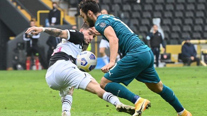 Gelandang AC Milan asal Turki Hakan Calhanoglu (kanan) dan gelandang Argentina Udinese Rodrigo De Paul memperebutkan bola pada pertandingan sepak bola Serie A Italia antara Udinese dan AC Milan di Stadion Friuli, alias