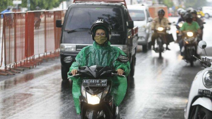 PEngguna jalan menggunakan jas hujan saaat melintas di jalan Panembahan Senopati, Kota Yogyakarta, Kamis (13/8/2020). Badan Meteorologi, Klimatologi dan Geofisika (BMKG) Yogyakarta menyebutkan terjadi gangguan cuaca sesaat berupa belokan atau perlambatan kecepatan arah angin di wilayah Pulau Jawa dan hal inilah yang memicu turunnya hujan di musim kemarau ini.