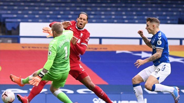 Penjaga gawang Everton Inggris Jordan Pickford (tengah) menangani bek Liverpool asal Belanda Virgil van Dijk (kiri) selama pertandingan sepak bola Liga Premier Inggris antara Everton dan Liverpool di Goodison Park di Liverpool, barat laut Inggris pada 17 Oktober 2020.