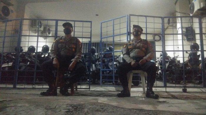 Petugas berjaga didepan kantor perusahaan Pinjol online di Samirono, Caturtunggal, Depok, Sleman, DIY yang digerebek petugas kepolisian dari Polda Jabar dan Polda DIY, Kamis (14/10/2021) malam.