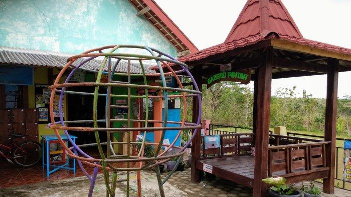 Suasana pelataran Perpusdes Pengkol yang sejuk dengan gazebo kayu, berlatar pemandangan perbukitan