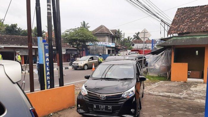Petugas gabungan memeriksa kendaraan dari luar daerah yang hendak masuk DIY di pos perbatasan Tempel, Jumat (12/2/2021)