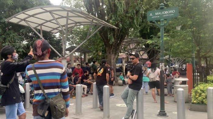 Pengunjung mengabadikan momen di bawah plang Jalan Malioboro. Foto diambil Jumat (12/2/2021) pukul 17.37 WIB