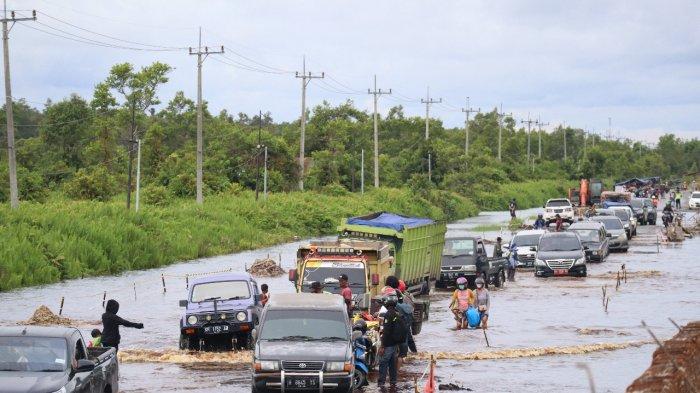 Kondisi Jalan Trans Kalimantan kawasan Desa Penda Barania Bukit Rawi, yang kembali terendam banjir mengakibatkan kemacetan kendaraan melintas kawasan tersebut.