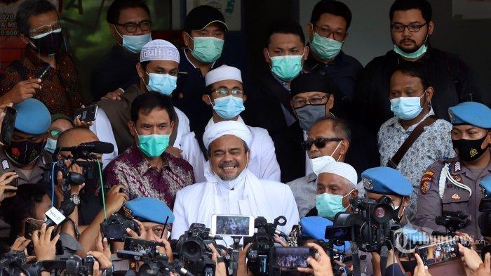 Pemimpin Front Pembela Islam (FPI), Muhammad Rizieq Shihab didampingi kuasa hukumnya, Munarman tiba di Mapolda Metro Jaya, Jakarta Selatan, Sabtu (12/12/2020). Kedatangan Rizieq Shihab untuk menjalani pemeriksaan sebagai tersangka dalam kasus pelanggaran protokol kesehatan terkait kerumunan yang terjadi di Petamburan.