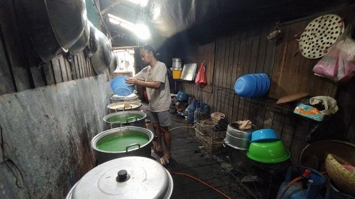 Anak dari Maskota Muradiah saat berada di dapur olahan miliknya, sedang menuang olahan kue talam ke sebuah panci. Proses memasak ini dibutuhkan waktu satu-setengah jam hingga dua jam lamanya. TRIBUNKALTIM.CO/MOHAMMAD FAIROUSSANIY