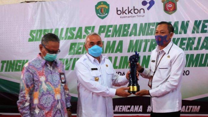 HARI KELUARGA - Gubernur Kaltim H Isran Noor saat memberikan sambutan dan ketika menyerahkan piala bergilir Harganas 2020 tingkat Provinsi Kaltim.
