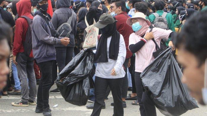 Mahasiswa tidak hanya ikut aksi unjuk rasa di Simpang Lembuswana, Rabu (7/10/2020) sore. Beberapa mahasiswa ikut turut menjaga kebersihan selama aksi penolakan UU Omnibus Law. TRIBUNKALTIM.CO/NEVRIANTO HARDI PRASETYO