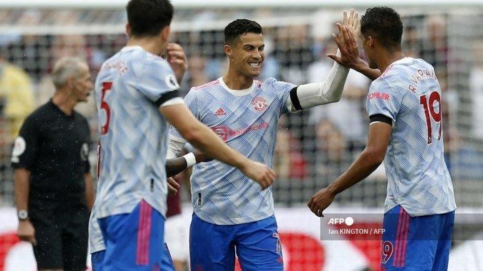 Striker Manchester United Portugal Cristiano Ronaldo (tengah) merayakan dengan bek Manchester United Prancis Raphael Varane (kanan) setelah mencetak gol pertama mereka selama pertandingan sepak bola Liga Premier Inggris antara West Ham United dan Manchester United di Stadion London, di London timur pada 19 September , 2021. (IAN KINGTON / AFP)