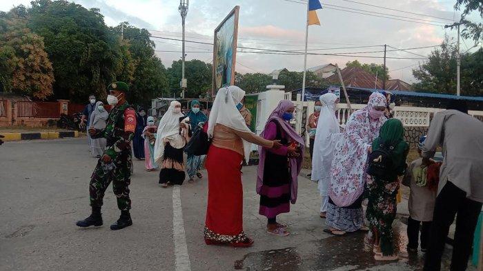 Umat Islam antre mencuci tangan sebelum memasuki halaman Masjid Agung Al Jihad Waingapu, Kamis 13 Mei 2021
