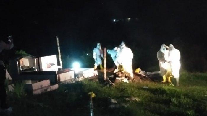 Petugas Satgas Covid-19 Kabupaten Manggarai sedang mengubur jenazah Tn IK.