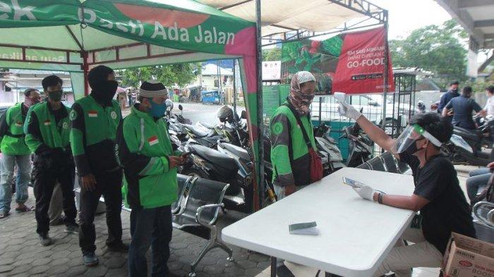SEMPROT DISINFEKTAN - Petugas menyemprotkan disinfektan ke sepeda motor mitra driver Gojek di Posko Aman J3K, Kantor Gojek, Jalan Wolter Monginsidi, Kecamatan Telukbetung Utara, Kota Bandar Lampung, Senin (16/11/2020). Gojek mendirikan Posko Aman J3K di Lampung untuk melindungi mitra-mitranya dari penularan Covid-19 melalui pemeriksaan suhu tubuh, pemberian perlengkapan penunjang kesehatan, dan melakukan penyemprotan disinfektan pada kendaraan agar para konsumen tetap nyaman saat menggunakan transportasi ini di tengah pandemi Covid-19.