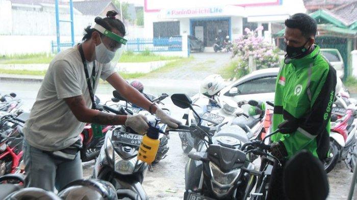 CEK SUHU TUBUH - Seorang mitra driver roda dua Gojek melaksanakan pengecekan suhu tubuh di Posko Aman J3K, Kantor Gojek, Jalan Wolter Monginsidi, Kecamatan Telukbetung Utara, Kota Bandar Lampung, Senin (16/11/2020). Gojek mendirikan Posko Aman J3K di Lampung untuk melindungi mitra-mitranya dari penularan Covid-19 melalui pemeriksaan suhu tubuh, pemberian perlengkapan penunjang kesehatan, dan melakukan penyemprotan disinfektan pada kendaraan agar para konsumen tetap nyaman saat menggunakan transportasi ini di tengah pandemi Covid-19.