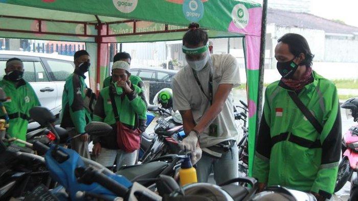 SEMPROT DISINFEKTAN - Petugas menyemprotkan disinfektan ke sepeda motor mitra driver Gojek di Posko Aman J3K, Kantor Gojek, Jalan Wolter Monginsidi, Kecamatan Telukbetung Utara, Kota Bandar Lampung, Senin (16/11/2020). Gojek mendirikan Posko Aman J3K di Lampung untuk melindungi mitra-mitranya dari penularan Covid-19 melalui pemeriksaan suhu tubuh, pemberian perlengkapan penunjang kesehatan, dan melakukan penyemprotan disinfektan pada kendaraan agar para konsumen tetap nyaman saat menggunakan transportasi ini di tengah pandemi Covid-19.
