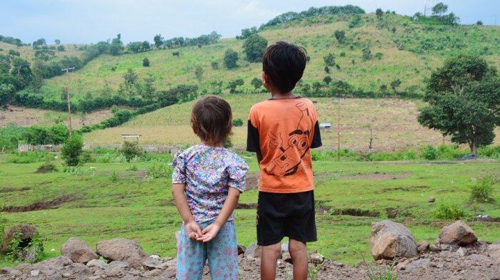 HUTAN GUNDUL: Anak-anak di Kabupaten Dompu, Provinsi NTB melihat ke arah hutan gundul yang beralih fungsi menjadi lahan tanaman jagung. Foto ini diambil 10 April 2019.