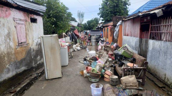 BERSIHKAN LUMPUR: Barang-barang rumah tangga ditumpuk warga di depan rumah untuk dibersihkan dari lumpur, usai banjir, Sabtu (3/4/2021).