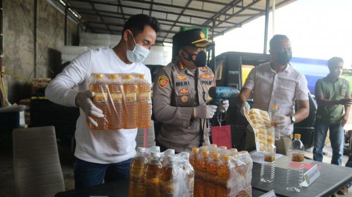 MINYAK ILEGAL: Dari kiri; Kasat Reskrim Kompol Kadek Adi Budi Astawa, Kapolresta Mataram Kombes Pol Heri Wahyudi menunjukkan minyak ilegal, di Mataram, Minggu (28/3/2021).
