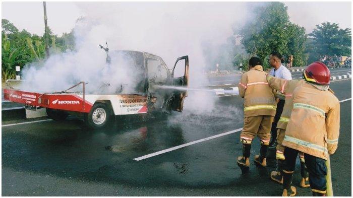 TERBAKAR: Petugas Pemadam Kebakaran Lombok Barat berusaha memadamkan api mobil pikap dealer yang terbakar, Sabtu (26/12/2020).