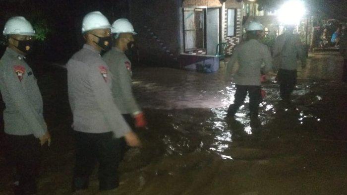 BANJIR: Polisi membantu warga terdampak banjir di Kabupaten Dompu, Rabu (24/3/2021) malam.