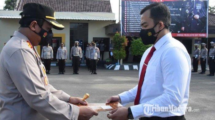 Kapolres Pamekasan, AKBP Apip Ginanjar (kiri) saat menyerahkan piagam penghargaan terhadap Kasatreskrim Polres Pamekasan, AKP Adhi Putranto Utomo (kanan) di halaman apel Mapolres Pamekasan, Senin (1/3/2021).