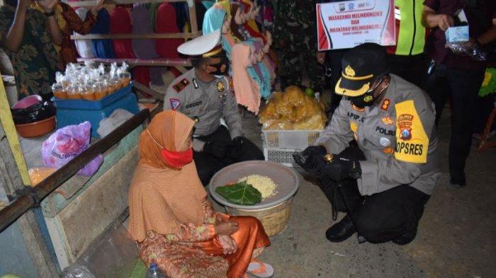 Kapolres Pamekasan, AKBP Apip Ginanjar saat memberikan masker gratis ke pedagang di Pasar 17 Agustus, Selasa (2/2/2021).