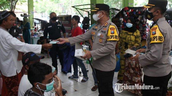 Kapolres Sampang, AKBP Abdul Hafidz saat membagikan masker kepada pengunjung dan pedagang di Pasar Srimangunan, Kabupaten Sampang, Madura, Selasa (2/2/2021).