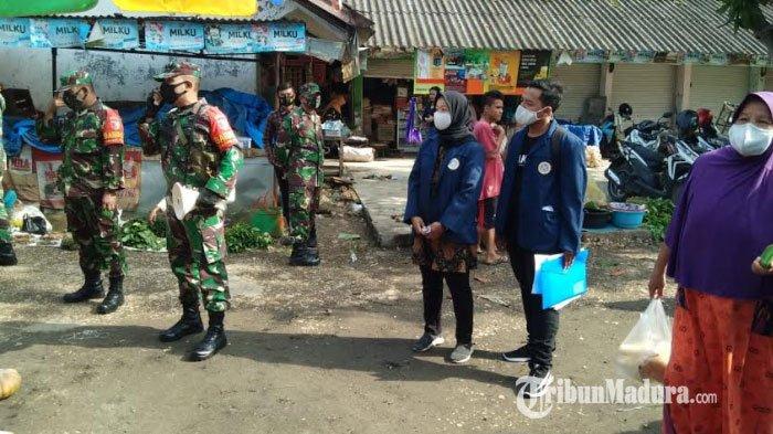 Personel Kodim Pamekasan saat berkolaborasi dengan mahasiswa KKN dari Unair Surabaya ketika membagikan masker gratis dan edukasi protokol kesehatan ke pedagang Pasar Gurem, Jumat (22/1/2021).
