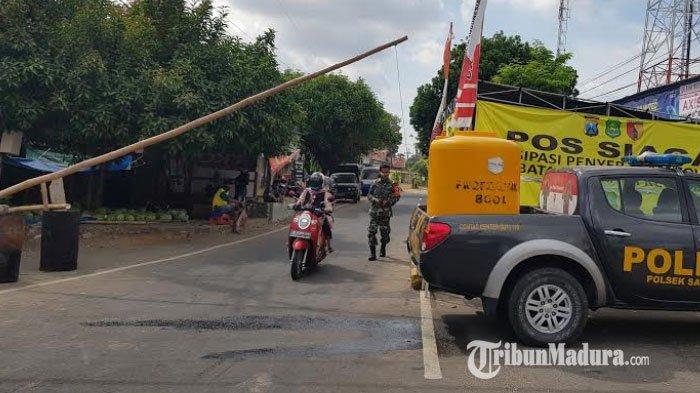 Sejumlah petugas memantau warga yang keluar masuk di pos jaga penerapan lockdown simpang tiga pintu masuk 7 desa/Kecamatan Saronggi, Sumenep pada Selasa (22/9/2020).