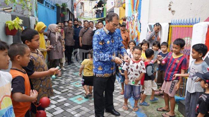 Walikota Makassar, Danny Pomanto memainkan latto-latto bersama anak-anak saat mengunjungi Lorong Wisata Haderslev Kelurahan Maloku, Kecamatan Ujung Pandang, Makassar, Selasa (29/11/2022). Latto-latto adalah permainan anak-anak yang mulai marak beberapa bulan terakhir. Mainan seharga Rp 3.500 hingga Rp 5.000 ini, marak dan terdengar di wilayah pemukiman urban kota