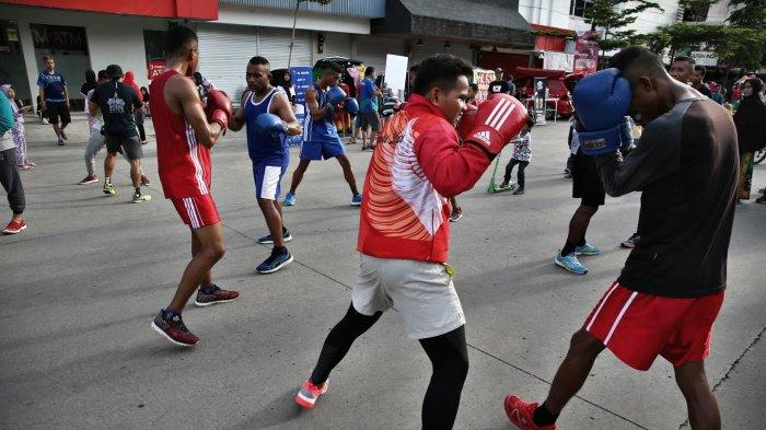 Sejumlah warga dibimbing para petinju profesional dari Pertina Makassar belajar cara bertinju dalam even boxing on the street di area car free day jalan Boulevard Makassar beberapa waktu lalu. Foto ini diabadikan sebelum badai pandemi Covid-19