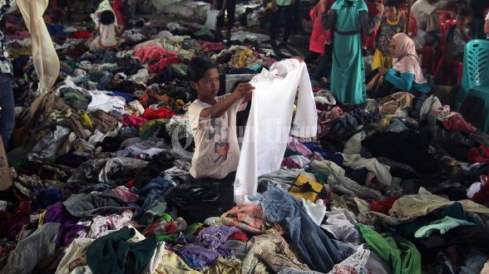 Sejumlah pengungsi korban gempa dan Tsunami Palu memilih baju bekas di gudang Makodam Hasanuddin, Makassar, Selasa (17/10). Bantuan tersebut datang dari perusahaan es krim Aice dengan menggunakan tiga mobil box untuk mengangkut bantuan berupa bahan makanan dan baju layak pakai yang diperlukan pengungsi.