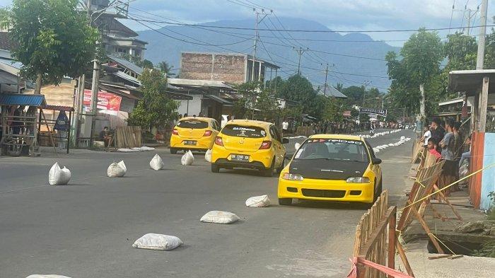 Dua mobil balap drag tengah beradu di Sirkuit Jalan Zakaria Imban, Poyowa Kecil, Kotamobagu Selatan Minggu (30/10/2022) dalam Kejuaraan Drag Race seri Kotamobagu.