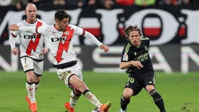 Santi Comesana (kiri) berduel dengan Luka Modric (kanan) pada laga penutup pekan ke-13 Liga Spanyol yang mempertemukan Rayo Vallecano vs Real Madrid di Vallecas Stadium, Selasa (8/11/2022) dini hari WIB.