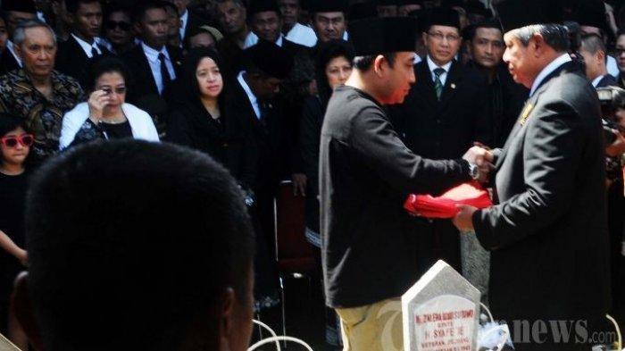 Presiden Susilo Bambang Yudhoyono (kanan) memberikan bendera Merah Putih penutup peti jenazah kepada keluarga mendiang Ketua MPR RI, Taufik Kiemas, yang diwakili oleh putranya, Mohammad Rizki Pratama