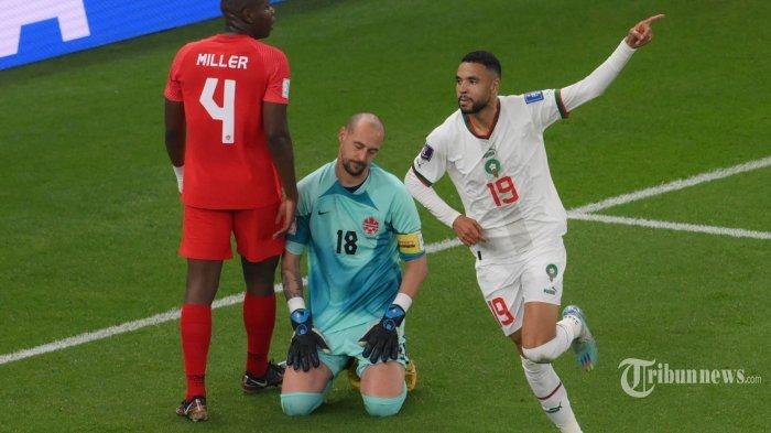 Penyerang Timnas Maroko, #19 Youssef En-Nesyri (kanan) melakukan selebrasi usai mencetak gol kedua timnya melewati penjaga gawang Timnas Kanada, #18 Milan Borjan (tengah) dalam laga sepak bola Grup F Piala Dunia 2022 Qatar antara Kanada melawan Maroko di Stadion Al-Thumama, di Doha, Qatar, Kamis (1/12/2022) waktu setempat.