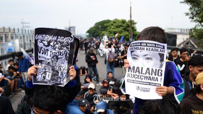 Ribuan Aremania melakukan aksi damai di Fly Over Arjosari atau Jl A Yani, Kota Malang, Jawa Timur, Minggu (20/11/2022). Massa aksi juga melakukan penempelan stiker dan membawa sepanduk tuntutan agar para korban mendapat keadilan. Aremania melakukan aksi damai di sejumlah titik pada hari ini di Malang Raya menuntut kasus Tragedi Kanjuruhan yang menewaskan 135 korban jiwa dapat di usut tuntas. Lembaga Perlindungan Anak (LPA) Jawa Timur sebut ingatan anak, korban Tragedi Kanjuruhan terhadap peristiwa tragis belum sepenuhnya dapat dilupakan.
