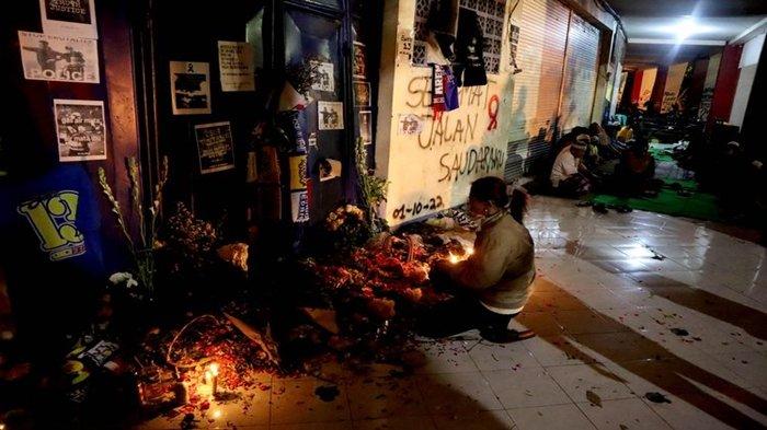 Seorang wanita dan warga melakukan doa bersama di antara gate 12 dan 13 pasca tragedi yang terjadi pada pekan ke-11 Liga 1 2022-2023 seusai pertandingan bertajuk Derbi Jawa Timur, Arema FC melawan Persebaya Surabaya di Stadion Kanjuruhan Kepanjen, Kabupaten Malang, Selasa (4/10/2022) malam.