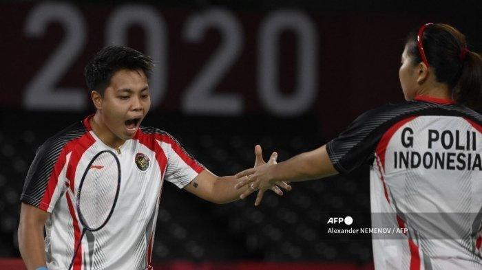 Apriyani Rahayu (kiri) dari Indonesia bereaksi setelah mendapatkan poin dari Greysia Polii Indonesia dalam pertandingan final bulu tangkis ganda putri melawan Jia Yifan dari China dan Chen Qingchen dari China selama Olimpiade Tokyo 2020 di Musashino Forest Sports Plaza di Tokyo pada 2 Agustus 2021. (Alexander NEMENOV / AFP)