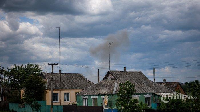 Asap dan kotoran membubung setelah penembakan di desa yang baru-baru ini direbut kembali di utara Kharkiv, Ukraina timur, pada 25 Mei 2022, di tengah invasi Rusia ke Ukraina. (Photo by DIMITAR DILKOFF / AFP) (AFP/DIMITAR DILKOFF)