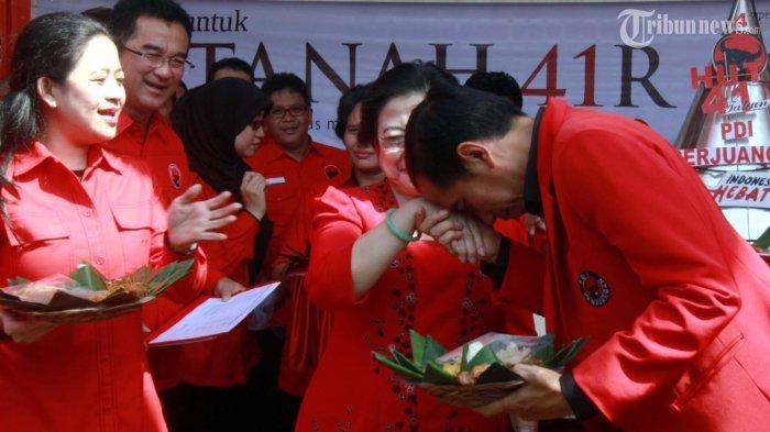 Kader PDI Perjuangan yang juga Gubernur DKI Jakarta Joko Widodo ( kanan) mencium tangan Ketua Umum DPP PDI Perjuangan Megawati Soekarnoputri (ketiga kiri) usai menerima Nasi Tumpeng saat perayaan Hari Ulang Tahun Ke-41 PDI Perjuangan di Kantor DPP PDI Perjuangan Jalan Raya Lenteng Agung 99, Jakarta, Jumat (10/1/2014). Megawati Soekarnoputri meminta kepada seluruh kader untuk fokus mengantarkan PDI Perjuangan menjadi pemenang Pemilu Legislatif 2014 atau memperoleh suara minimal 20 persen.